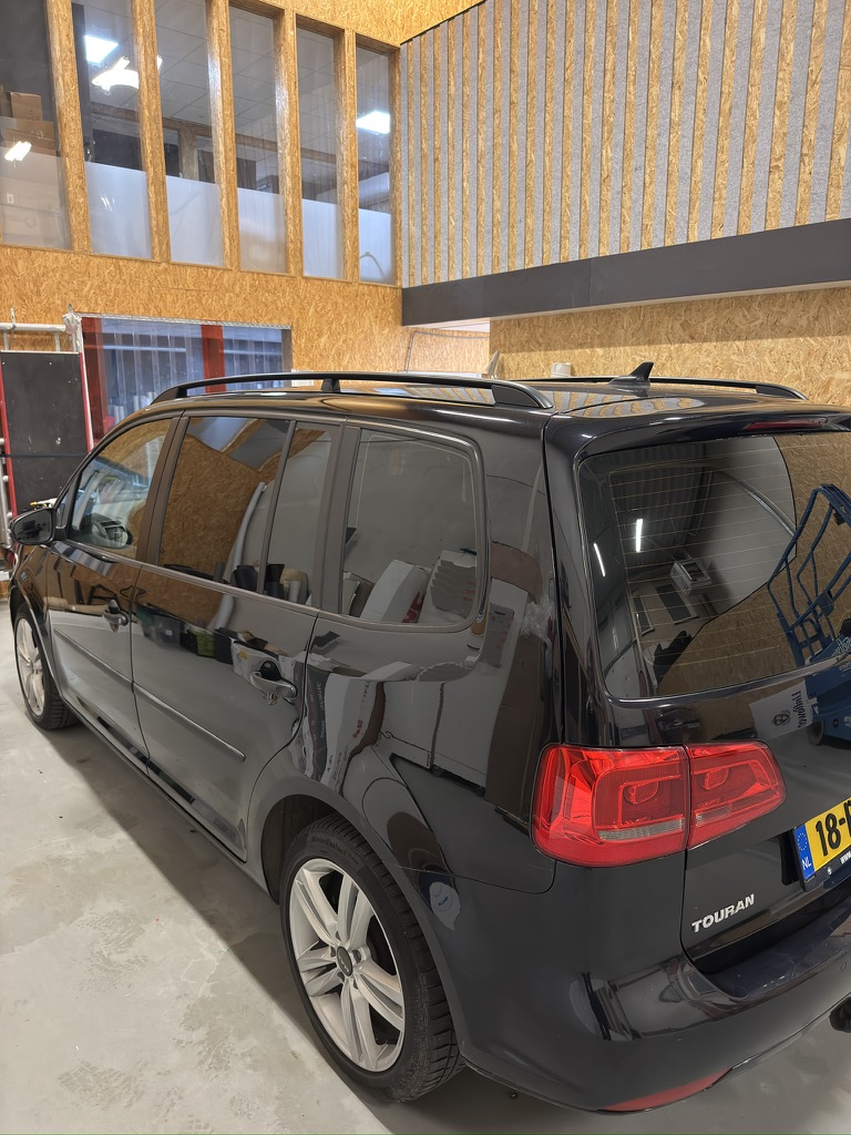 Zwarte Volkswagen Touran met egaal getinte achterruiten