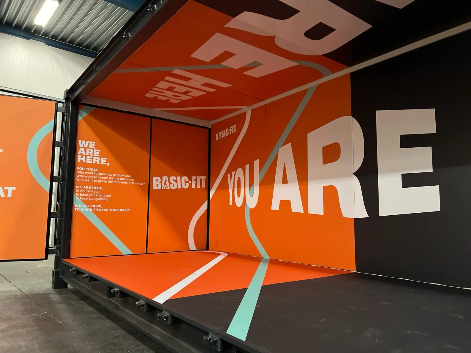 Een festivalcontainer die midden in het merk staat, de wrap over de lange zijde.