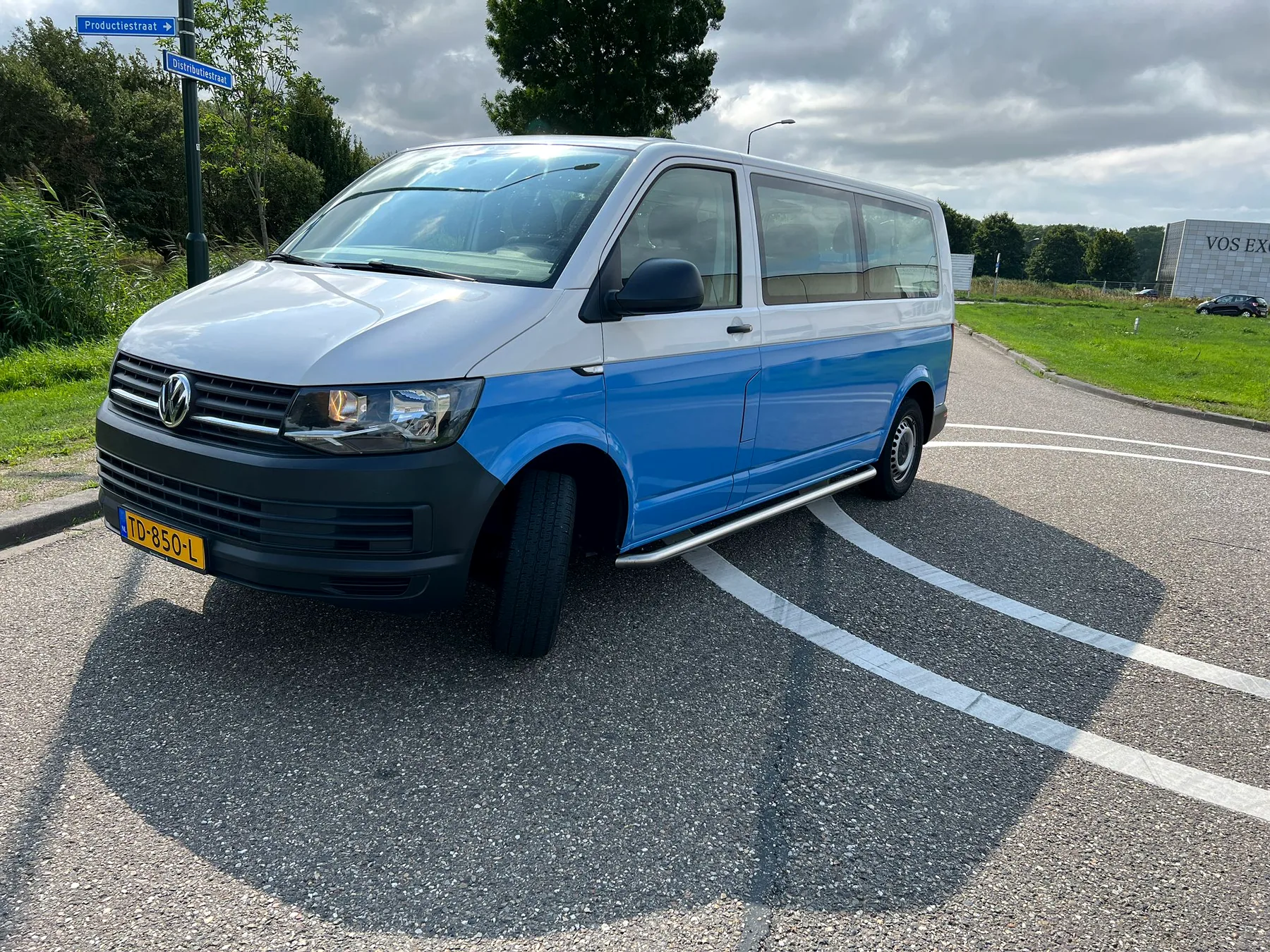 Volkswagen buscamper met blauwe deelwrap, schuin van voren