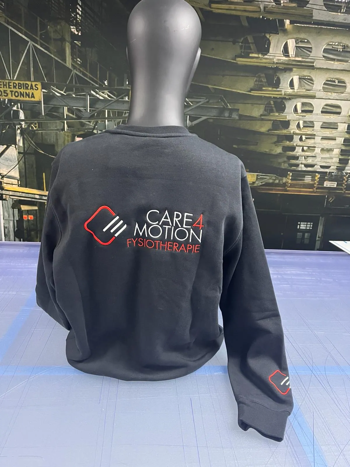 Het geborduurde logo op de kleding.