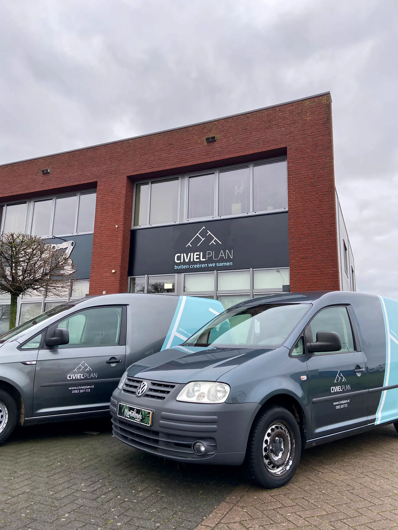 Twee beletterde bedrijfswagens van CivielPlan voor het eigen bedrijfspand