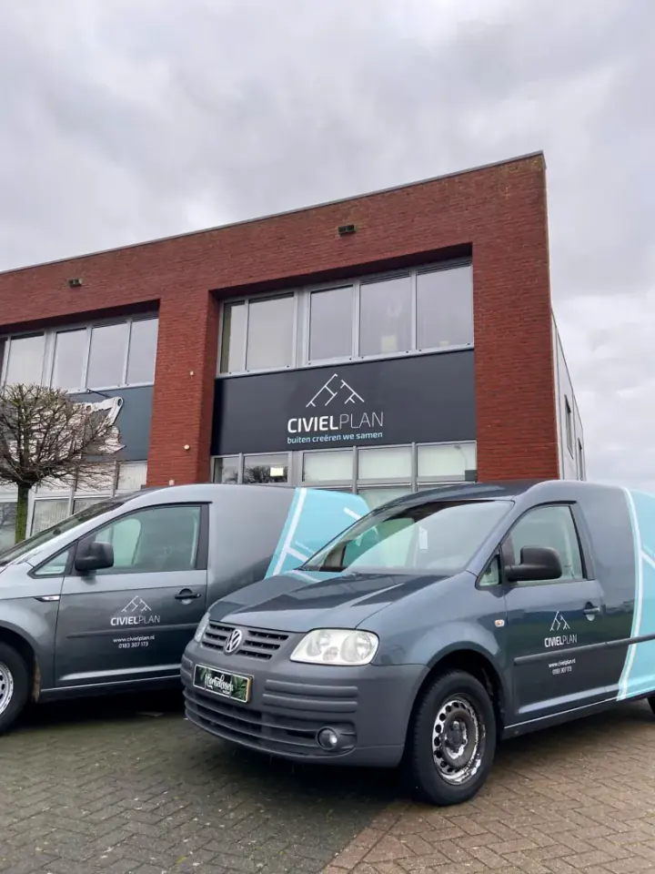 Twee beletterde bedrijfswagens van CivielPlan voor het eigen bedrijfspand