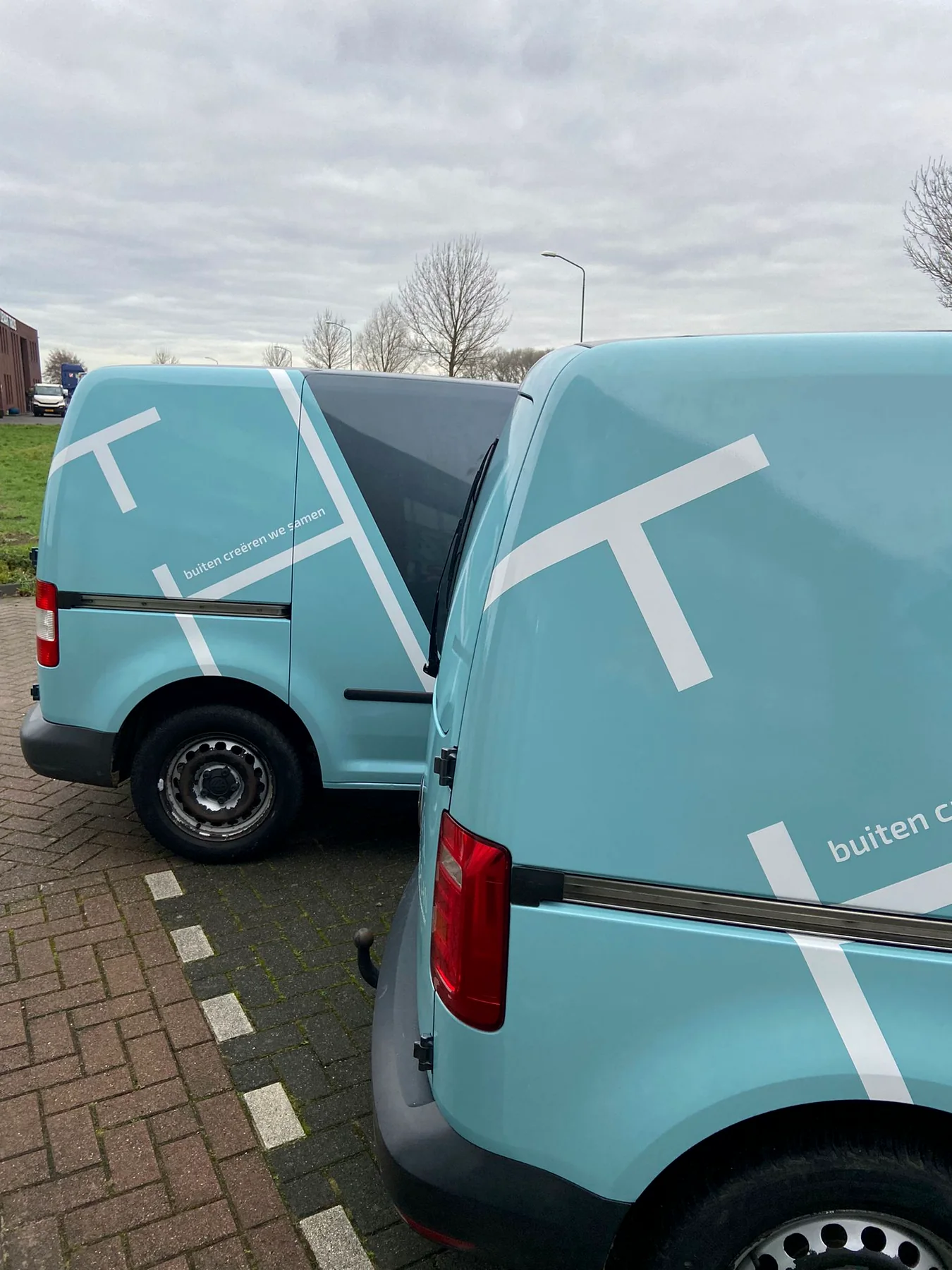 Twee Civielplan-bestelwagens met lichtblauwe achterpanelen en witte lijnstructuur