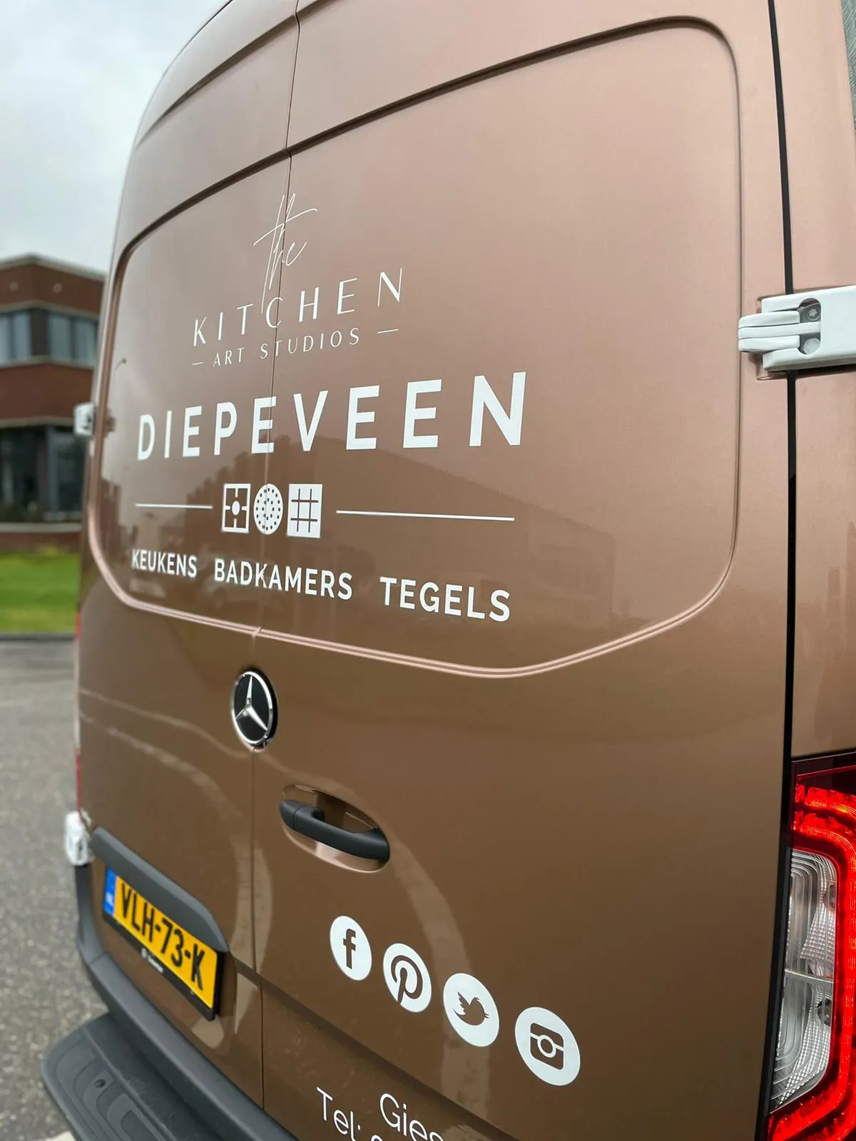 Een rijdende showroom met gedeeltelijke wrap, achterzijde met merk, diensten en contactpunten.