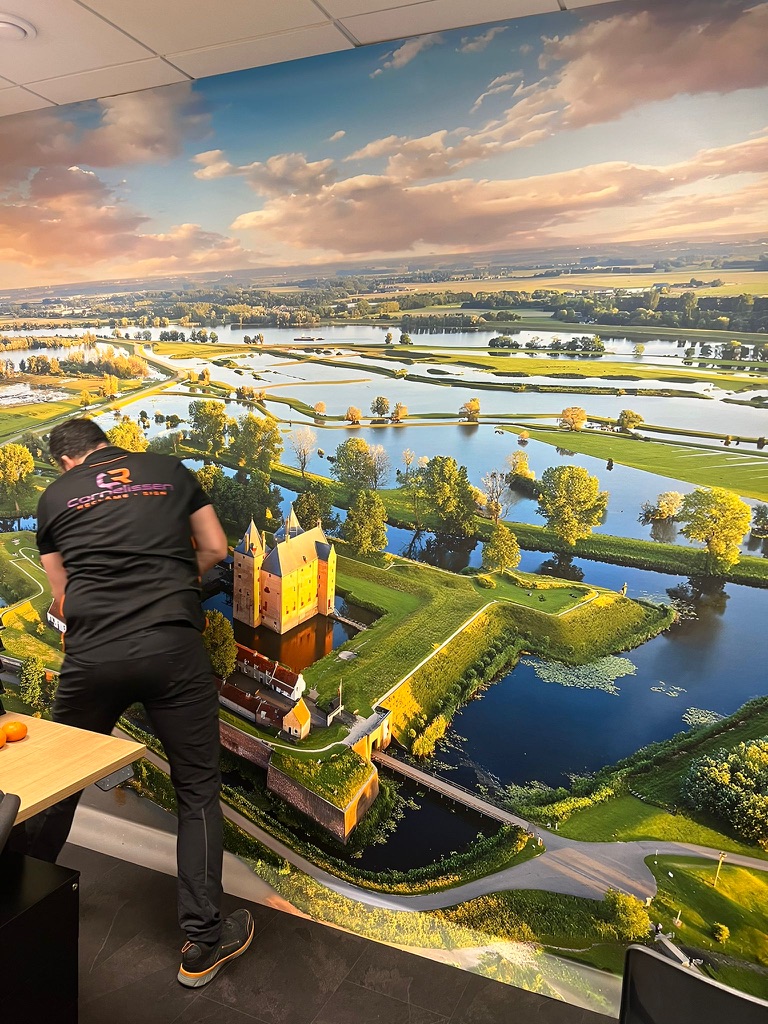 Monteur werkt het fotobehang rond het kasteelbeeld af