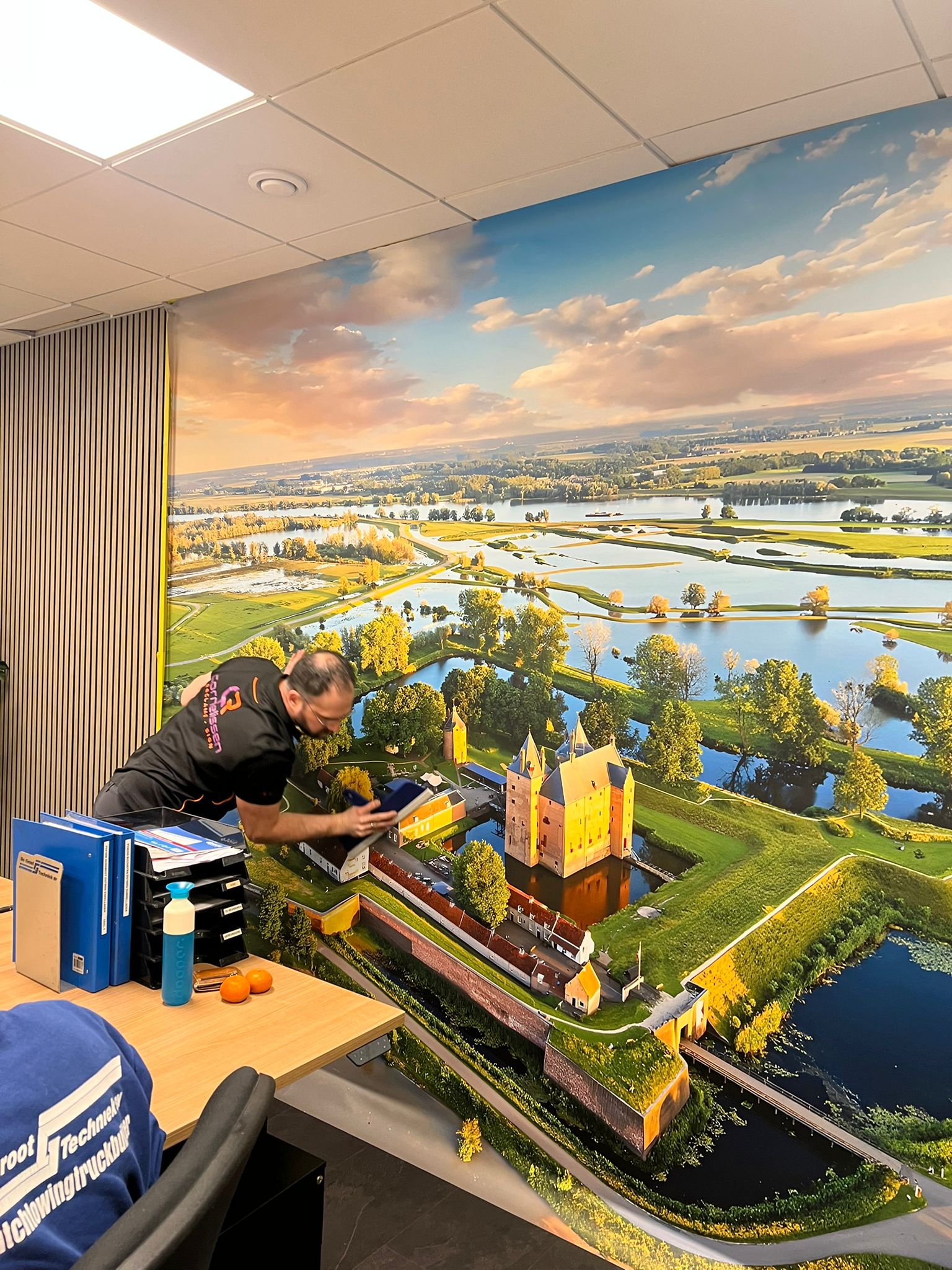 Montage van kamerbreed fotobehang in een kantoor