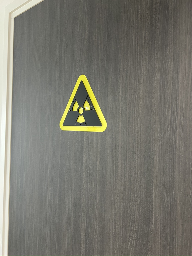 Detail van geel-zwart röntgenpictogram op een deur