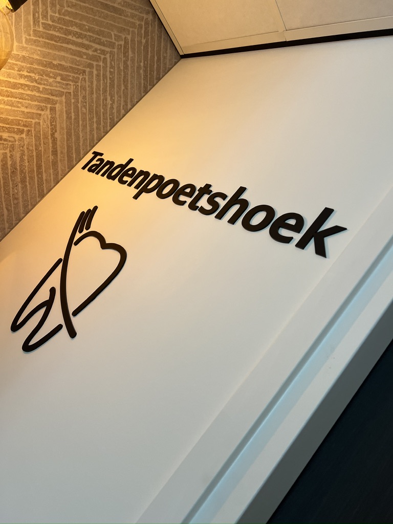 Detail van zwarte freesletters en tandpictogram