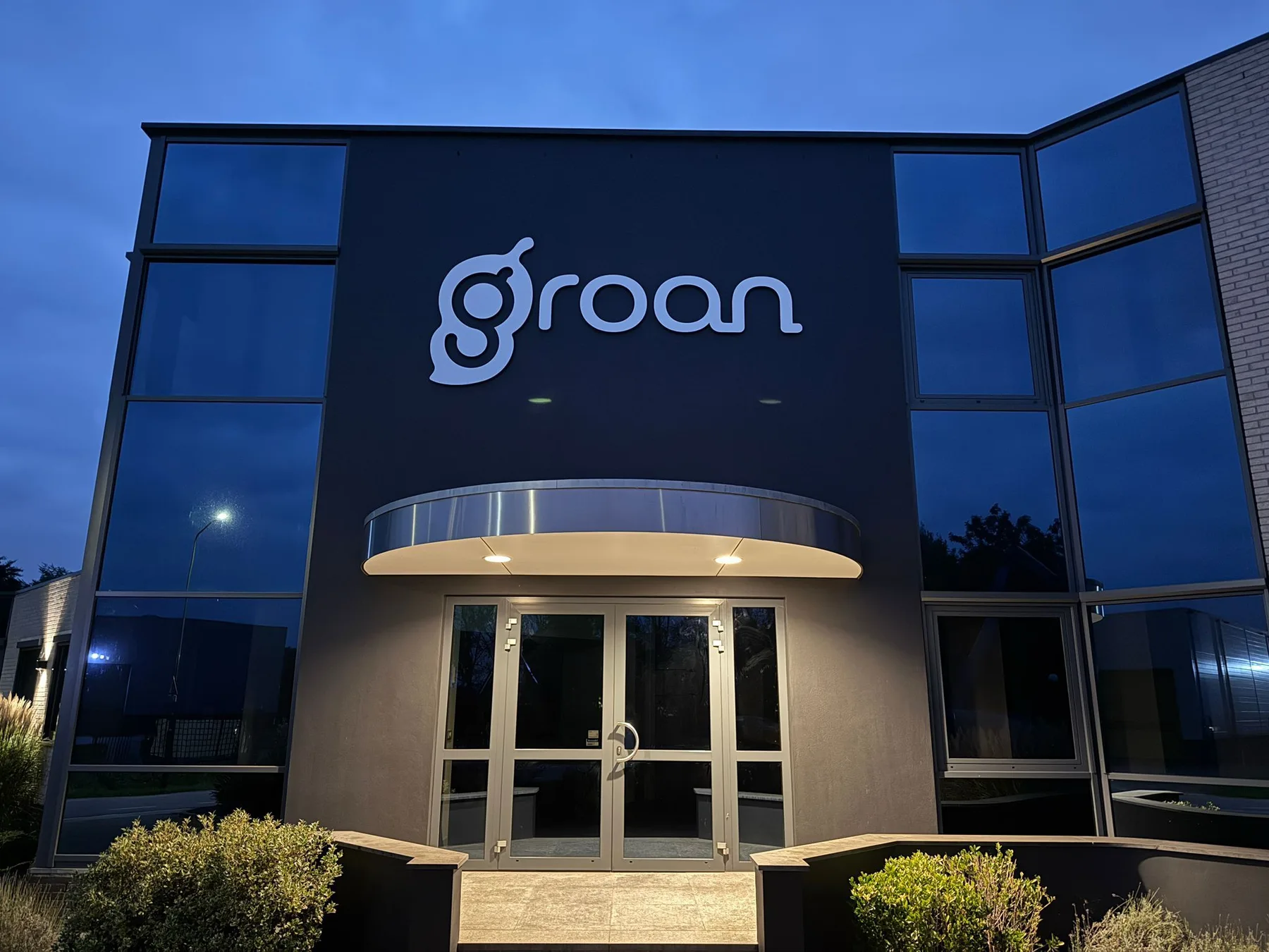 Verlichte gevelletters van Groan in de avond