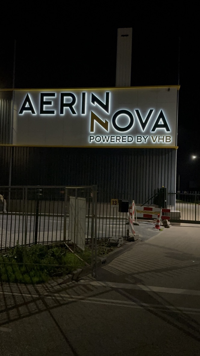 Verlichte Aerin Nova gevelletters in verticale nachtweergave