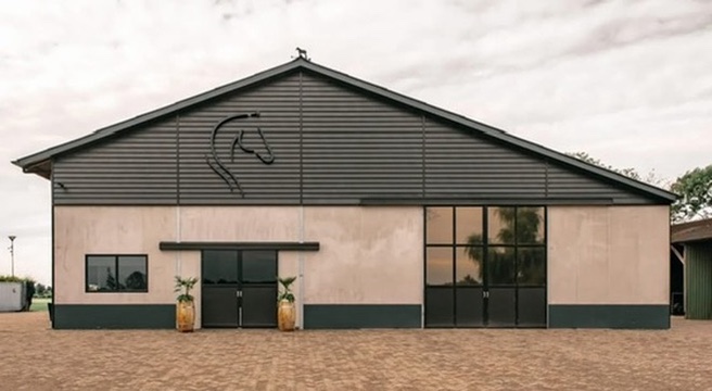 Frontale gevel van De Capreton met zwart paardenbeeldmerk