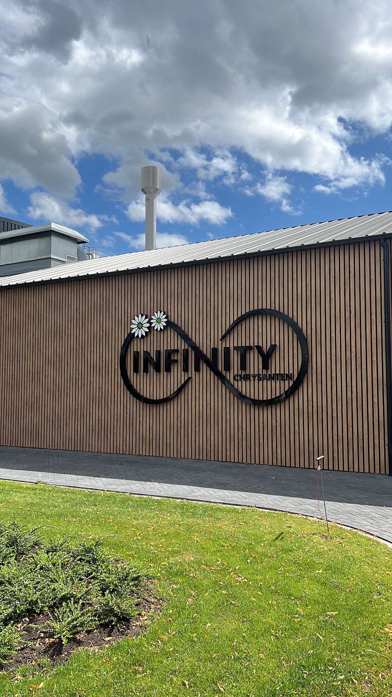 Definitief opgeleverde gevelreclame van Infinity Chrysanten op de houten bedrijfsgevel