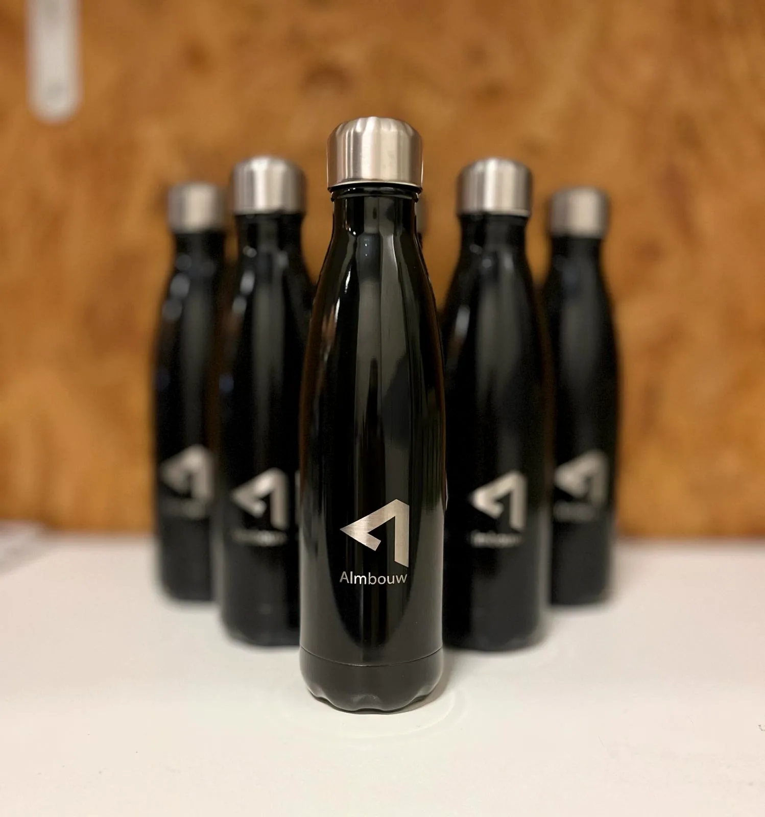 Serie zwarte drinkflessen met gegraveerd logo van ALM Bouw