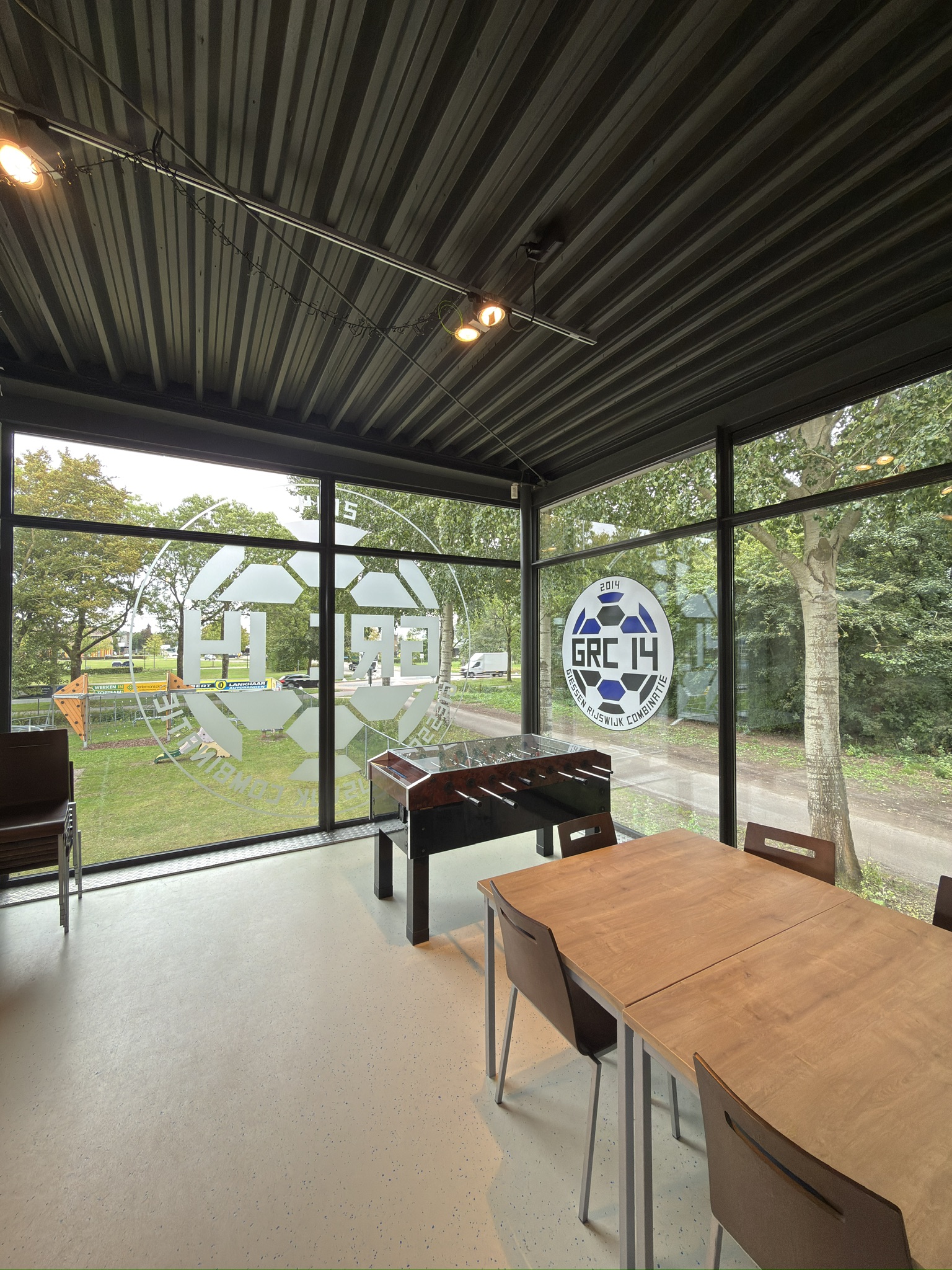 Dusted glasdecoratie met groot uitgesneden GRC 14-clubbeeld over meerdere ruiten