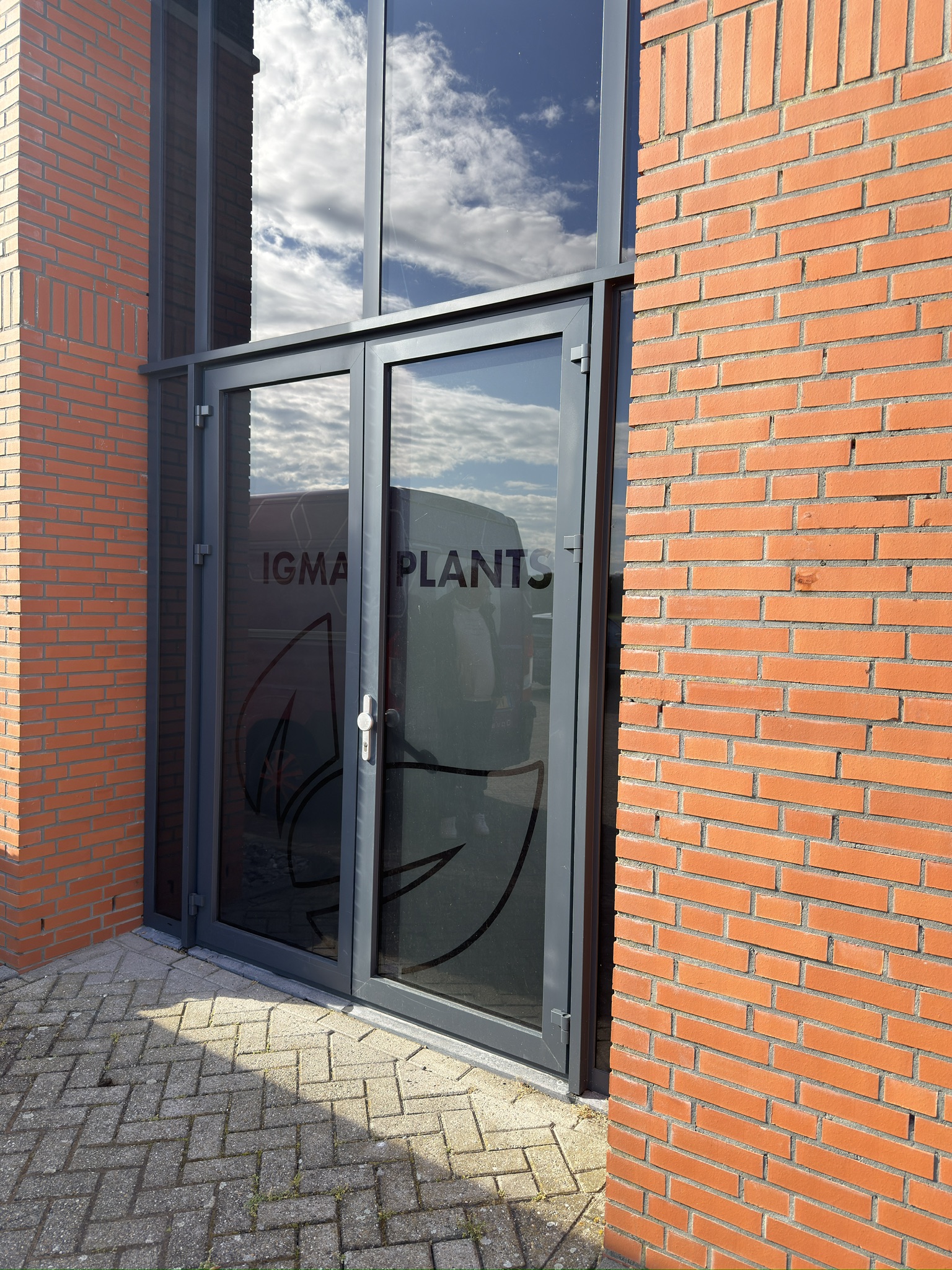 Schuin aanzicht van de transparante entree van IGMA Plants vóór montage