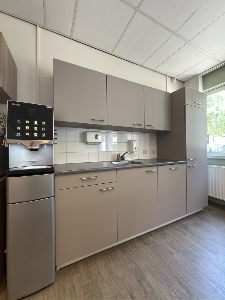 Overzicht van de taupe bedrijfskeuken na Re-Style