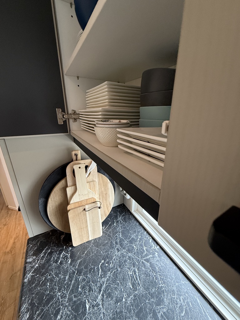 Detail van serviesplanken en de afgewerkte binnenrand van een bovenkast