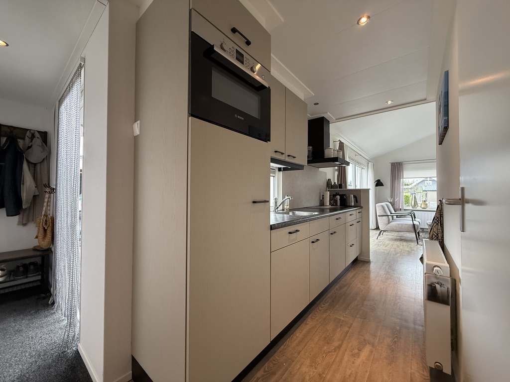 Complete lichte keuken gezien vanuit de gang