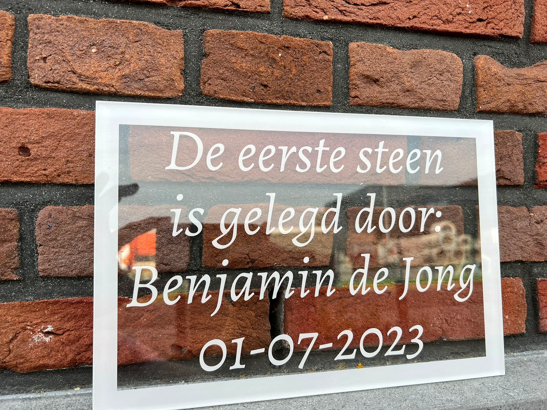 Transparante acrylaatplaat met gegraveerde tekst voor het leggen van de eerste steen
