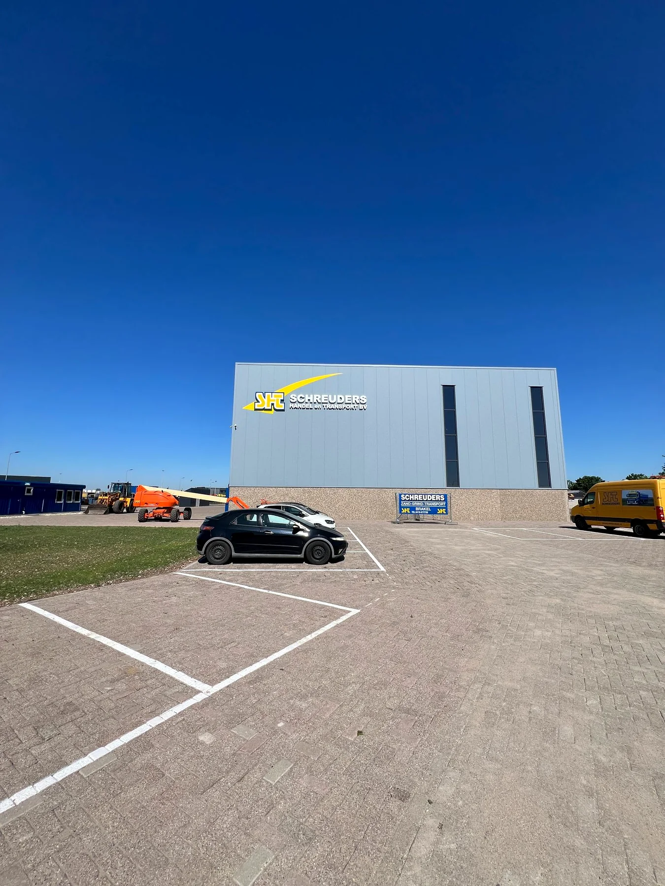 Gevelreclame van Schreuders gefotografeerd vanaf het parkeerterrein