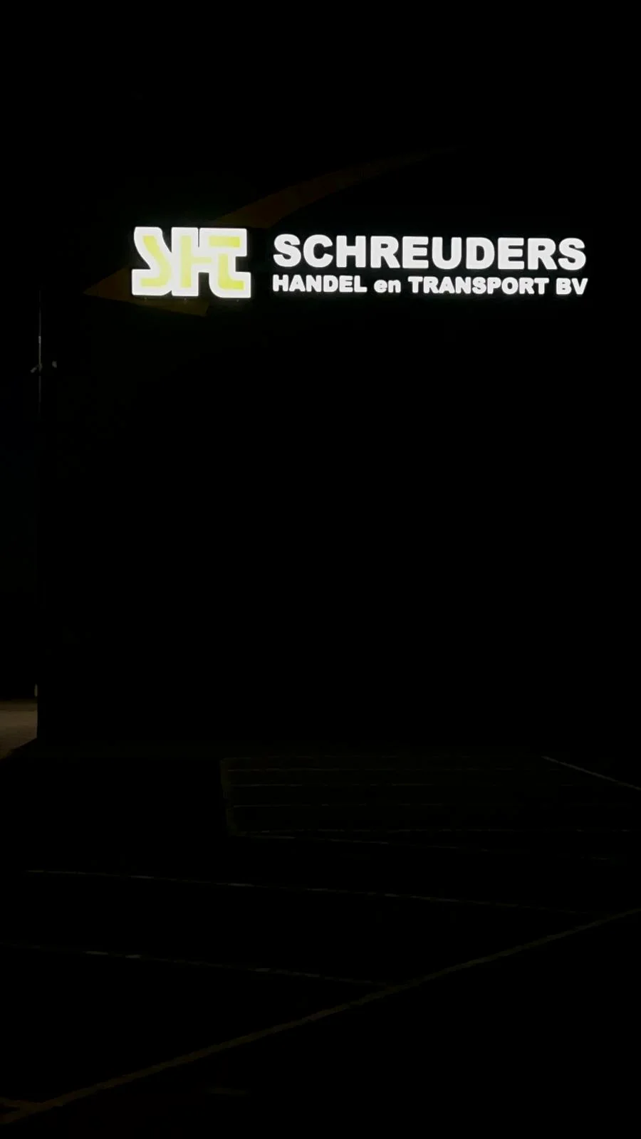 Close-up van het verlichte Schreuders-logo en de verlichte bedrijfsnaam