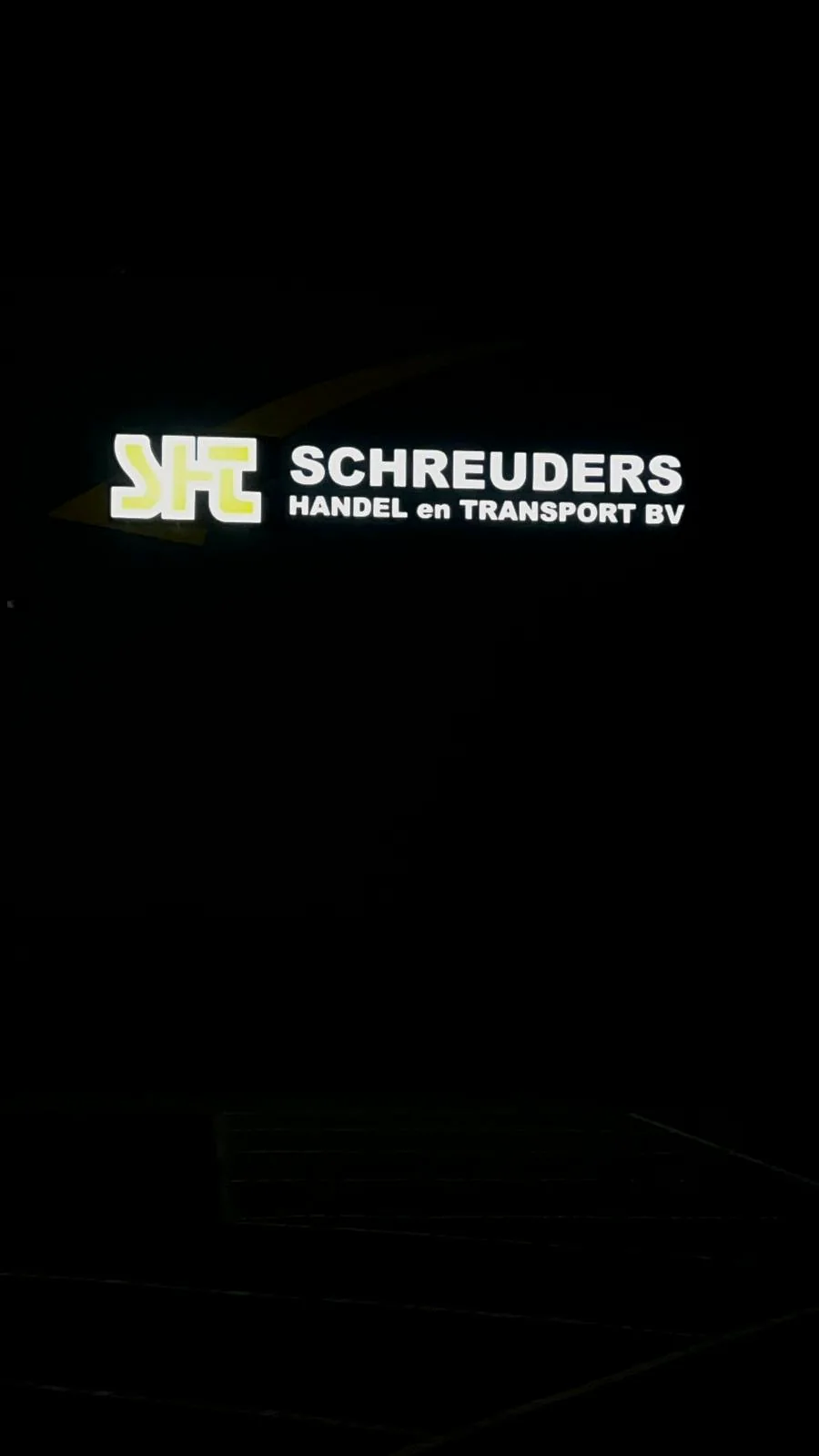 Verlichte bedrijfsnaam Schreuders Handel en Transport in de nacht