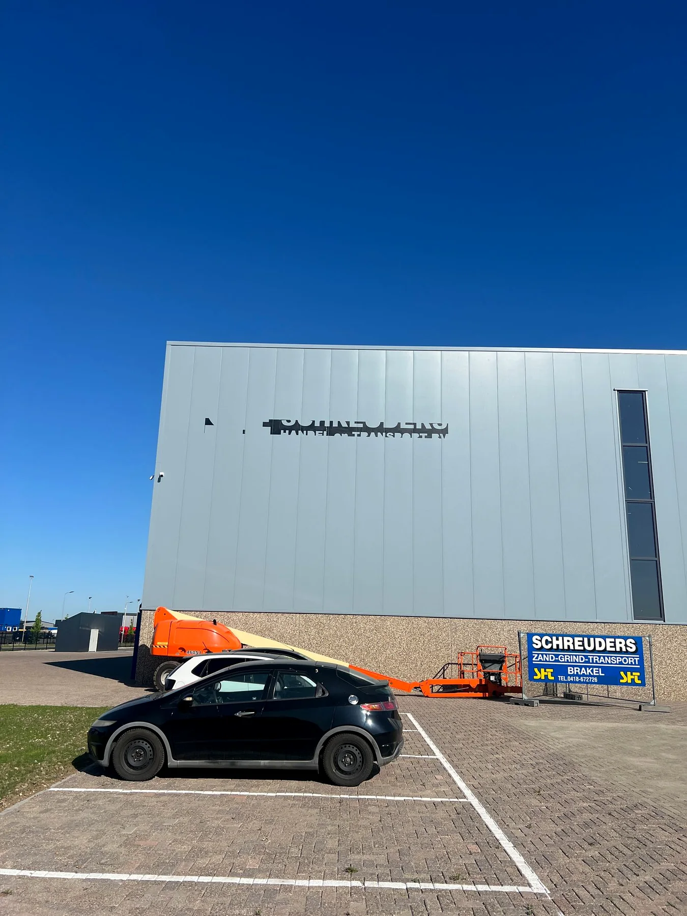 Grijze gevel van Schreuders voor de plaatsing van de nieuwe lichtreclame