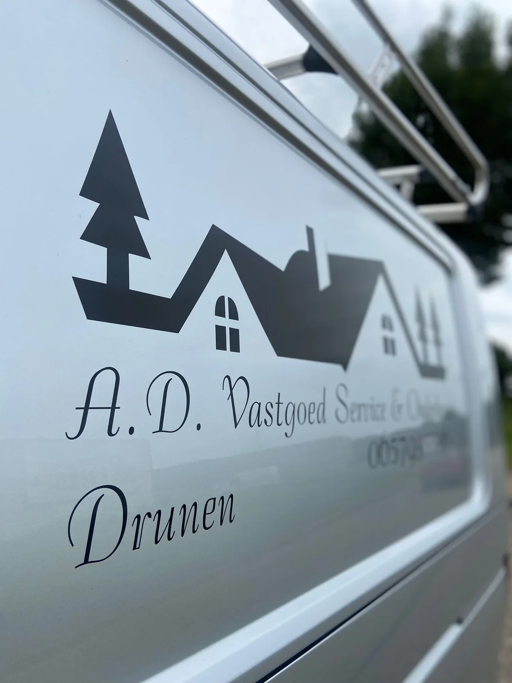 Donkere losse snijletters en logo op een witte bedrijfsbus