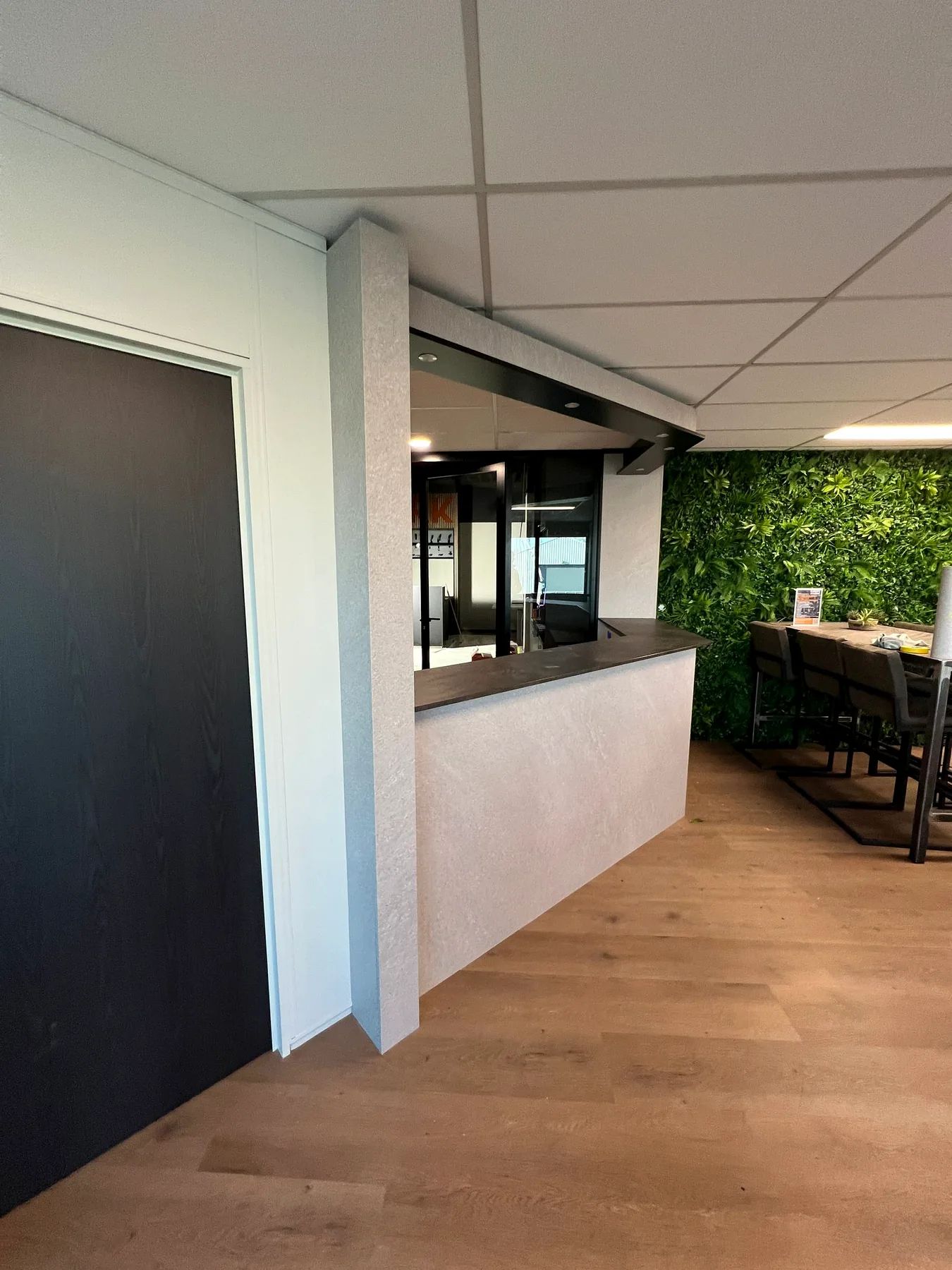 Dezelfde kantoorbalie na Re-Style met granietlook en donkere accenten