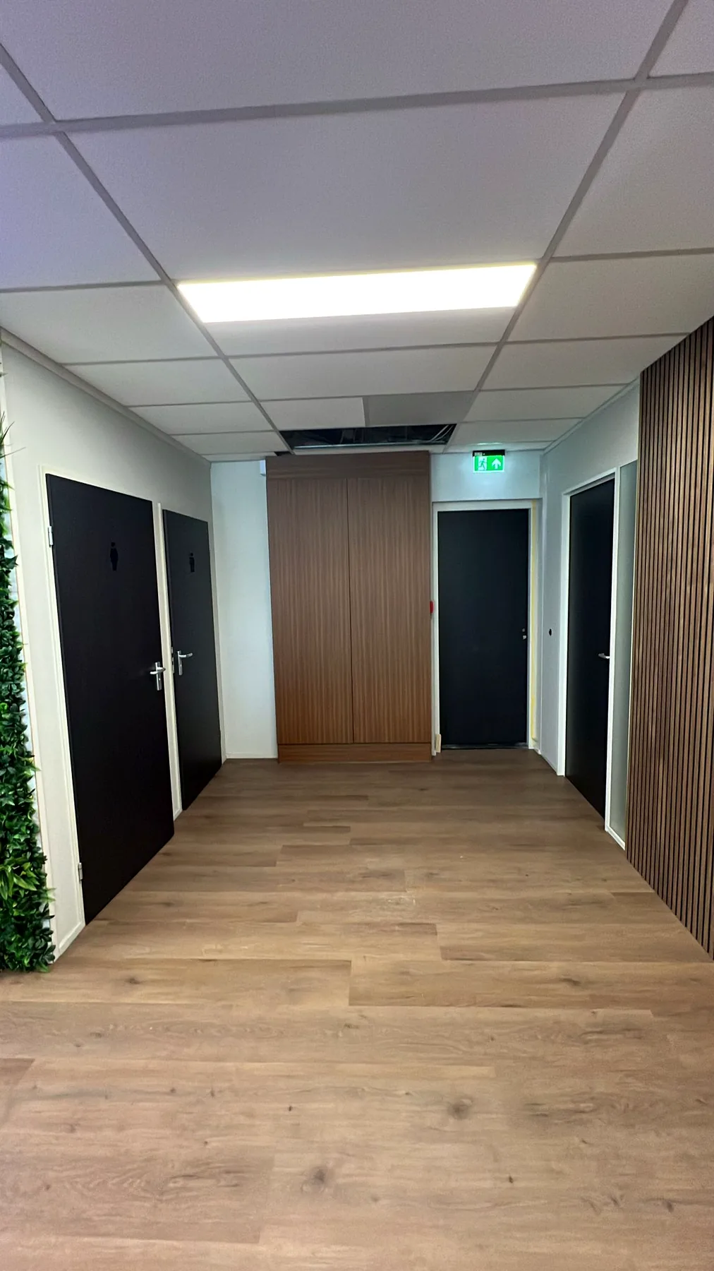 Kantoorgang met meerdere deuren in donkere houtlook na de restyle