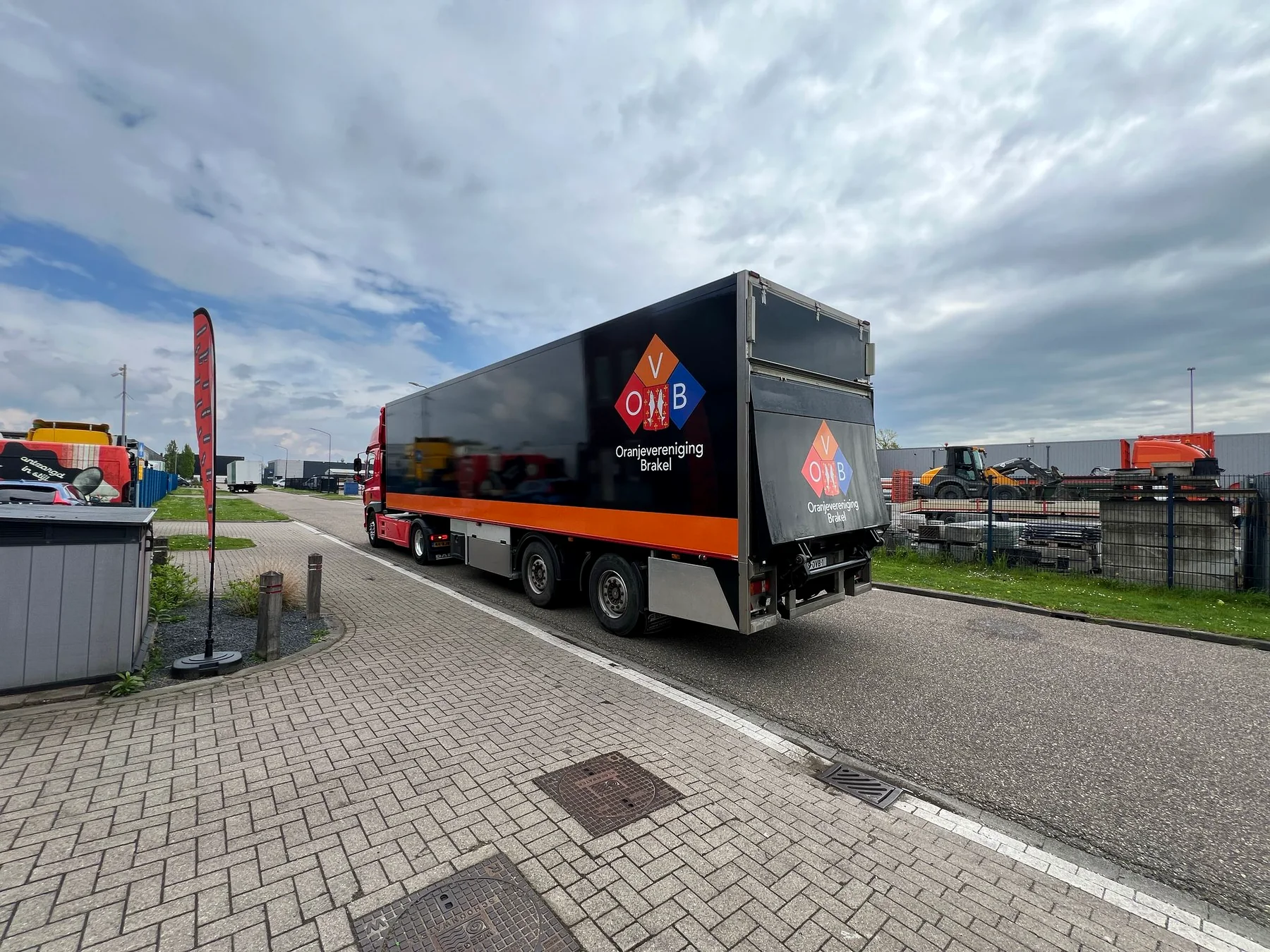 Zwart-oranje OVB-trailer vanuit schuin achterperspectief