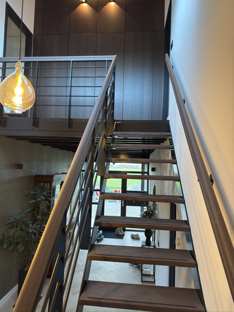 Open stalen trap na Re-Style met donkere houtlook op treden, bordes en leuningen