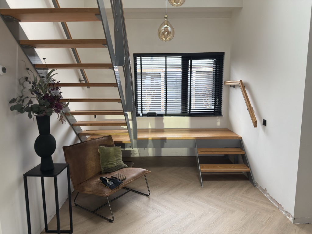 Open trap en bordes met lichte eiken afwerking vanuit de benedenruimte