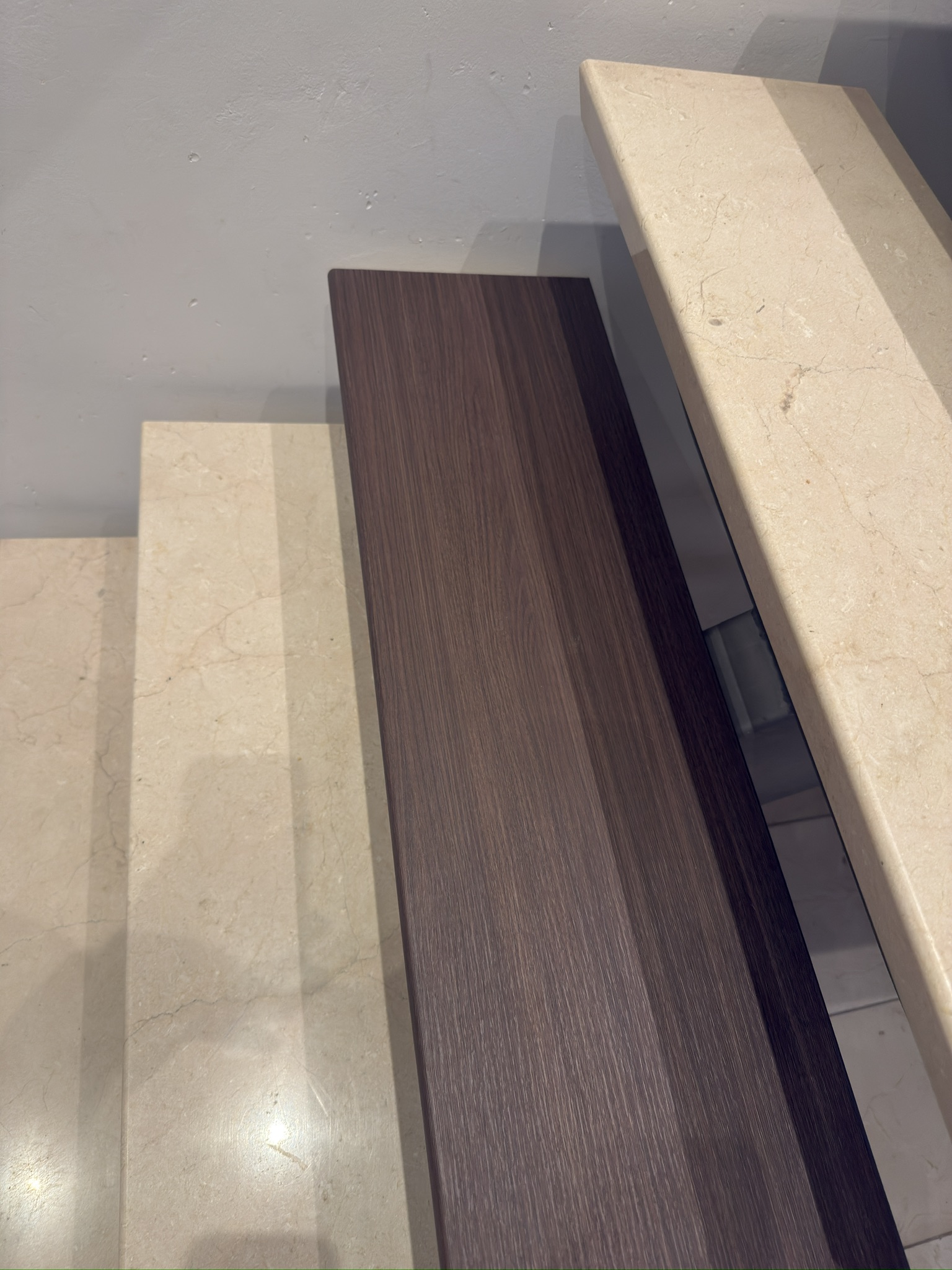 Detailvergelijking van een lichte traptrede en de nieuwe donkere houtlook