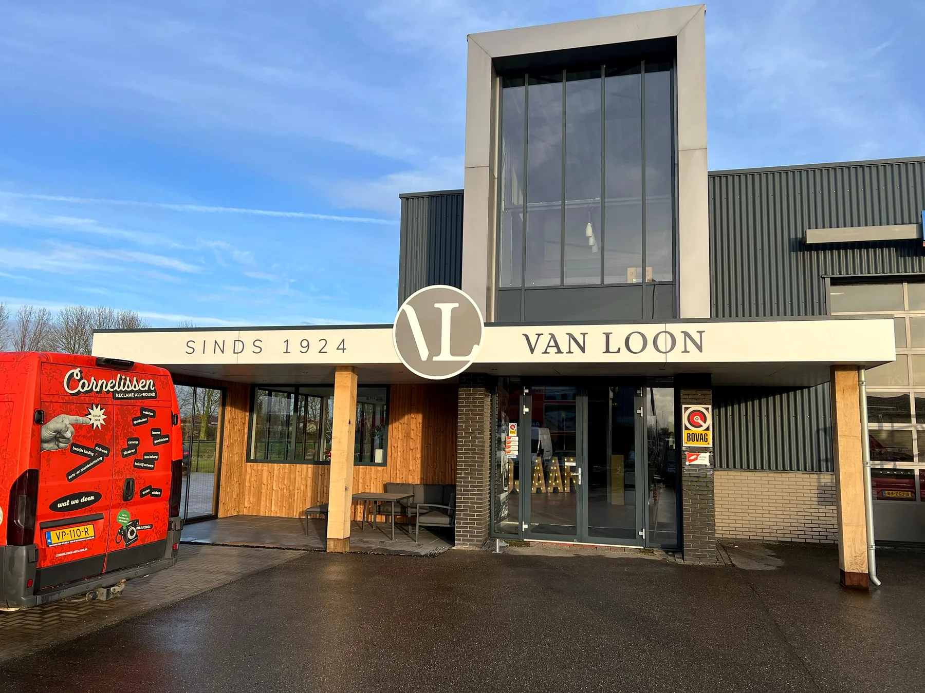 Brede gevelpresentatie van Van Loon met centraal rond beeldmerk