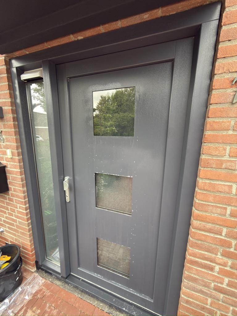 Montage van zonwerende folie op de glasvakken van een voordeur