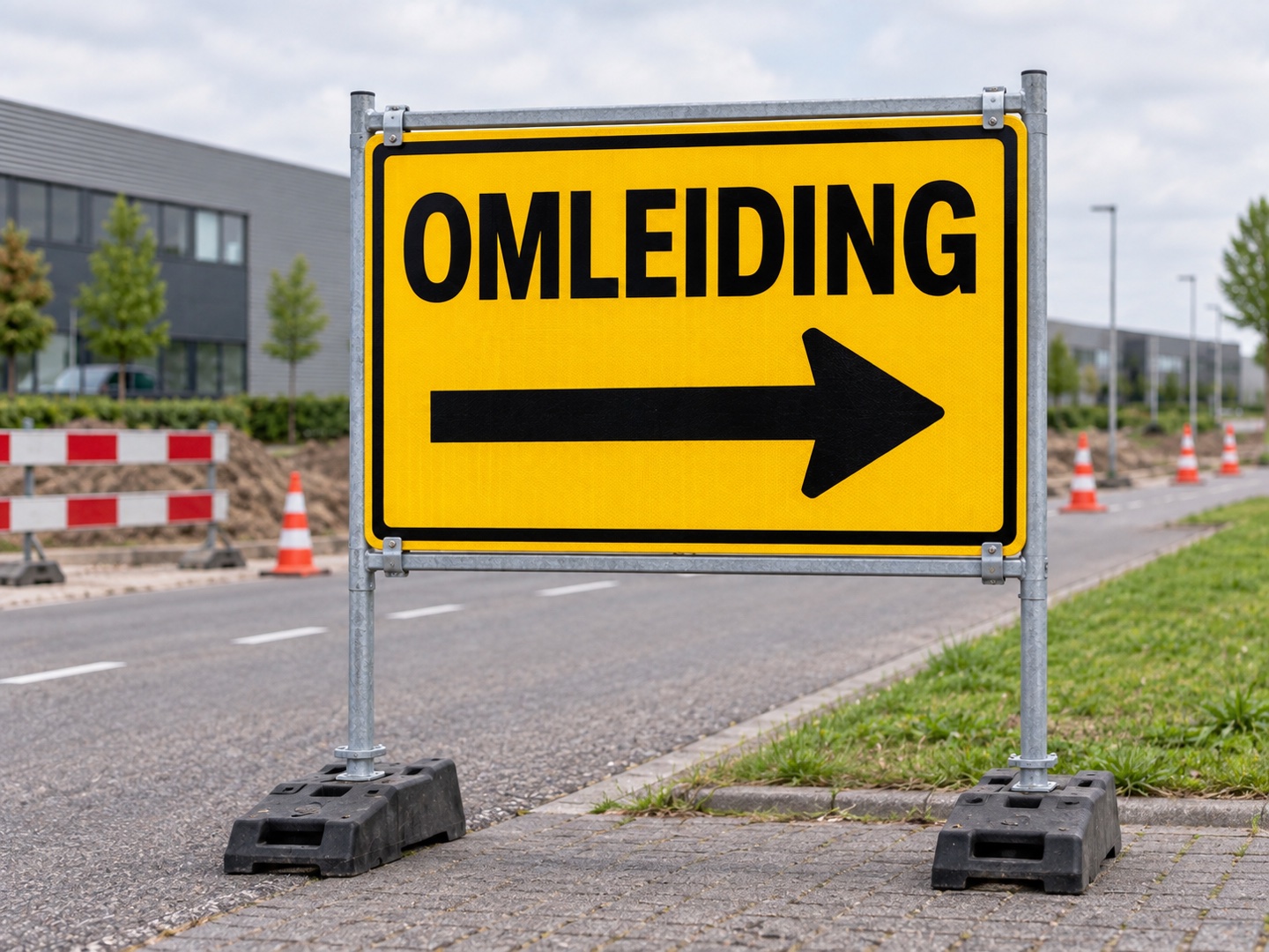 Geel tijdelijk omleidingsbord met zwarte pijl op een stevig metalen frame met verzwaarde voeten